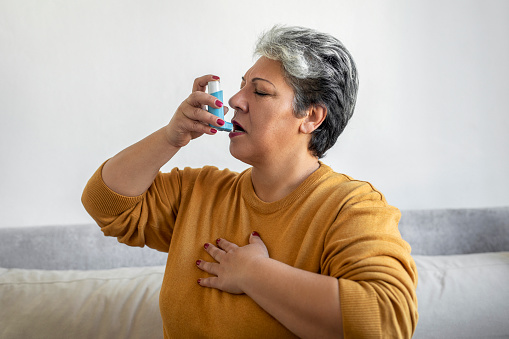 Woman using asthma inhale