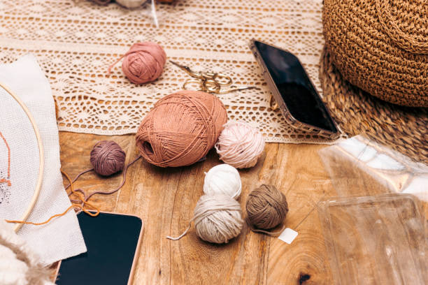 istock Punch Needle Workshop. Needlework. Materials for knitting at home on the table with phones. 1475236422