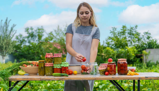 istock A woman preserves vegetables in jars. Selective focus. 1475237281