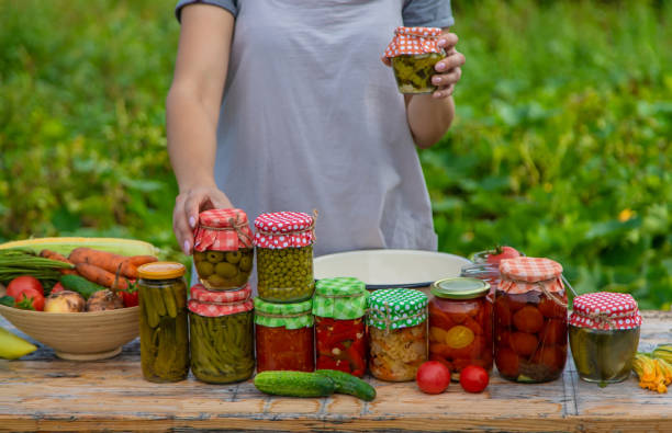 istock A woman preserves vegetables in jars. Selective focus. 1475237289