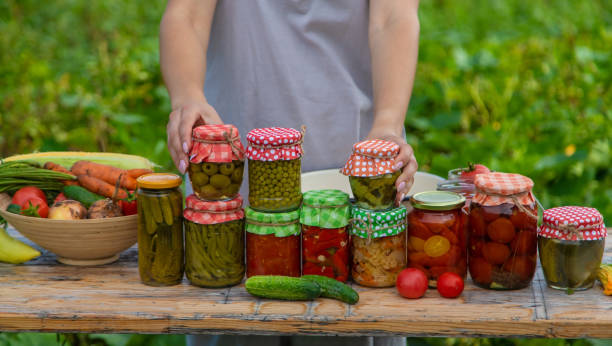 istock A woman preserves vegetables in jars. Selective focus. 1475237301