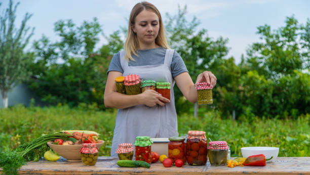 istock A woman preserves vegetables in jars. Selective focus. 1475237305
