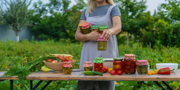 istock A woman preserves vegetables in jars. Selective focus. 1475237310