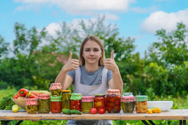 istock A woman preserves vegetables in jars. Selective focus. 1475237329