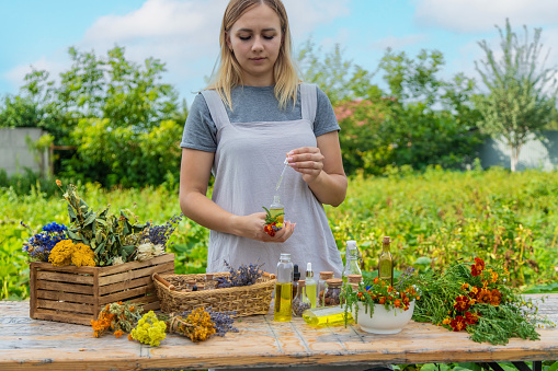 Woman with medicinal herbs and tinctures. Selective focus. Nature.