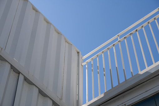 Low angle vision of white railings under blue sky