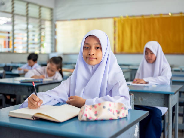 istock Girl in school uniform in class looking at camera 1475239163