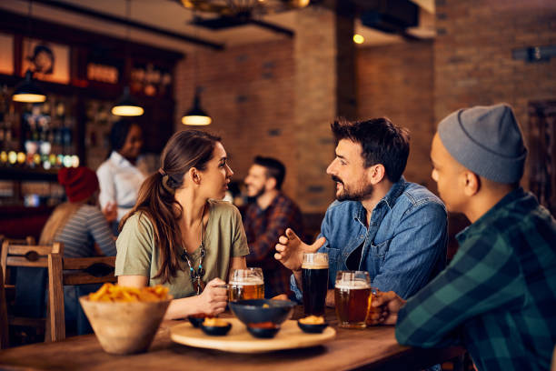 istock Young man and his friends communicating while gathering in a pub. 1475239857