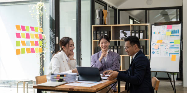 istock Group of young Asian business people brainstorming, looking at laptop computer 1475240077