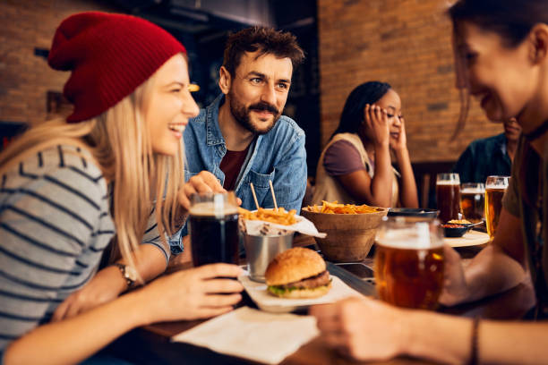 istock Group of young happy people drinking beer and talking in a pub. 1475240757