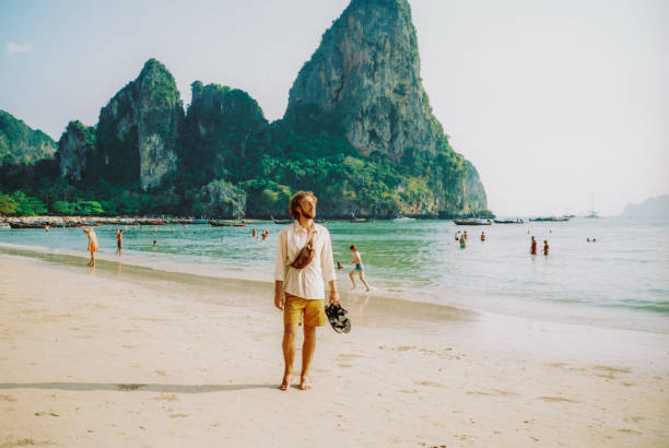 Young Caucasian man  walking on Railey beach and looking at stunning scenery. Contax T3. Point and shoot camera