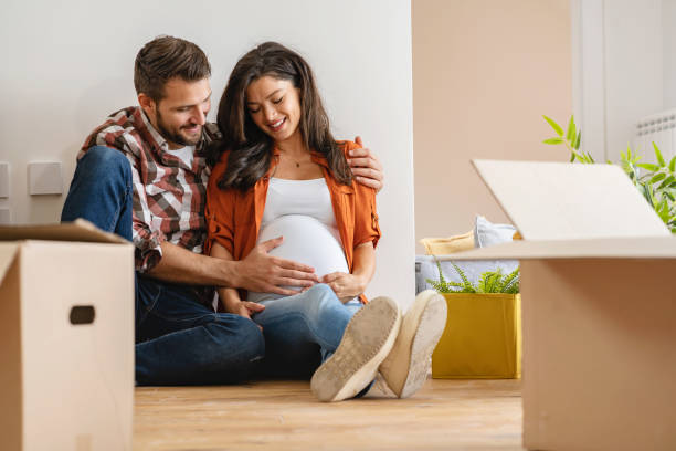 istock Young happy couple moved into an empty apartment sitting among cardboard boxes 1475244166