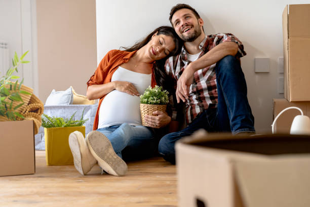 istock Young happy couple moved into an empty apartment sitting among cardboard boxes 1475244175