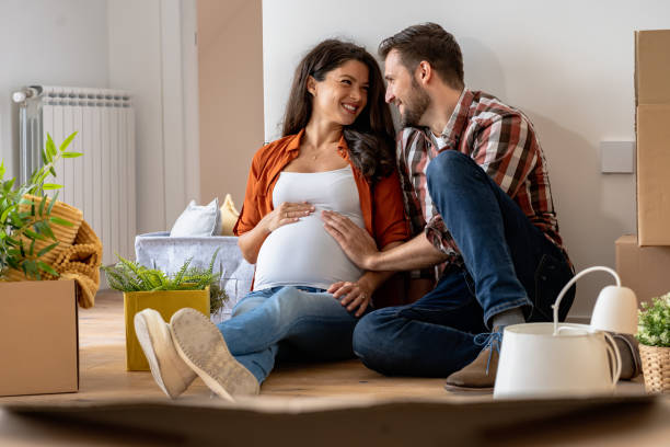 istock Young happy couple moved into an empty apartment sitting among cardboard boxes 1475244204