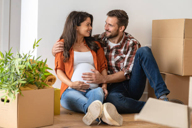 istock Young happy couple moved into an empty apartment sitting among cardboard boxes 1475244237