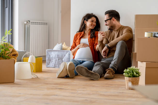 istock Young happy couple moved into an empty apartment sitting among cardboard boxes 1475244336