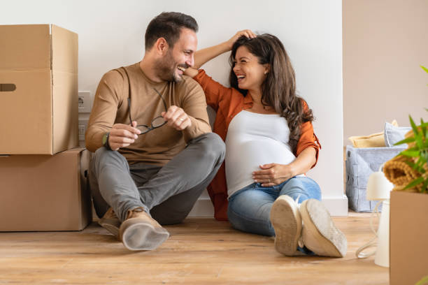 istock Young happy couple moved into an empty apartment sitting among cardboard boxes 1475244337