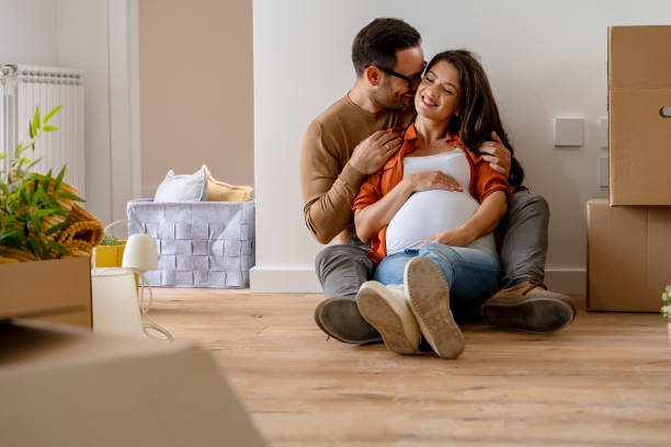 istock Young happy couple moved into an empty apartment sitting among cardboard boxes 1475244423