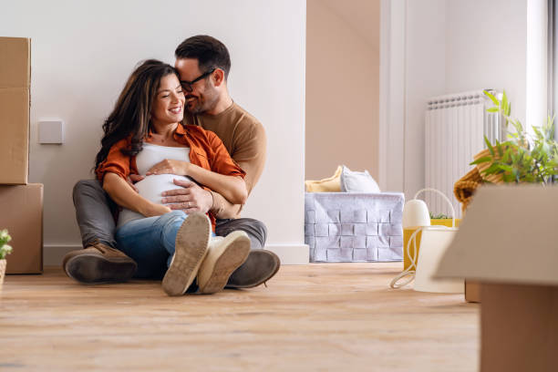 istock Young happy couple moved into an empty apartment sitting among cardboard boxes 1475244436