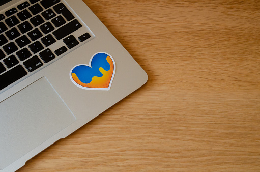 Close up laptop keyboard with heart shape blue and yellow sticker