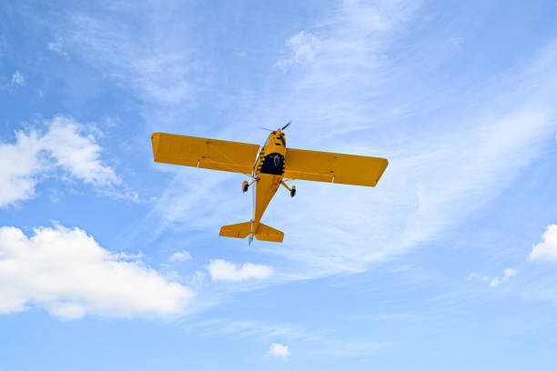 istock Light aircraft flying over blue sky 1475245845