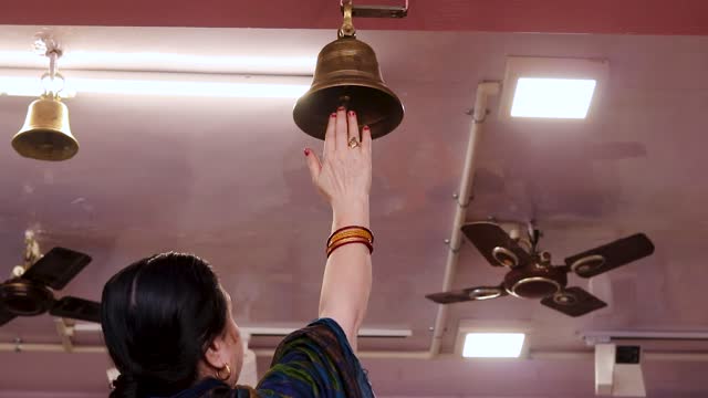 devotee ringing the holly bell at temple at morning
