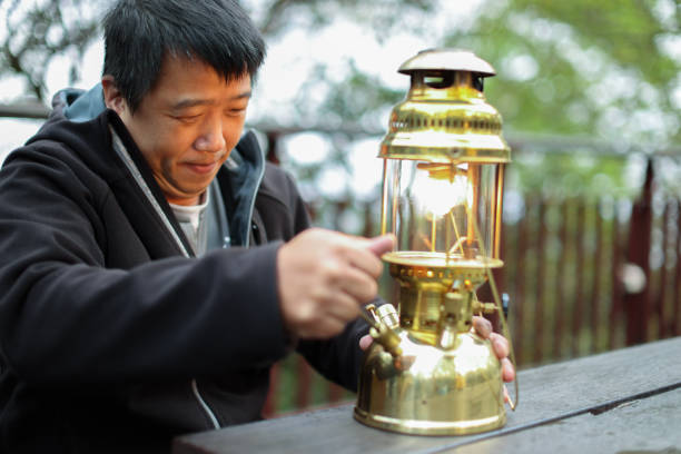 Close-up of a vintage design LED lantern hanging from the tent pole at an outdoor camping site.