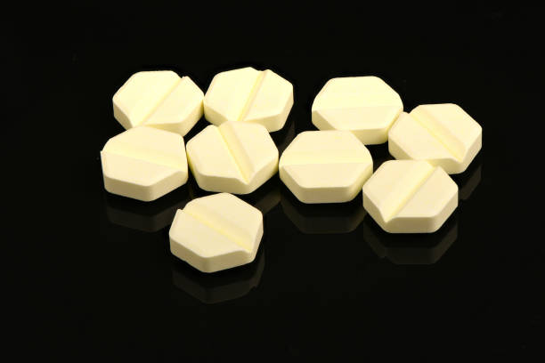 istock Hexagonal pills on light black acrylic background. Extreme closeup. 1475253332