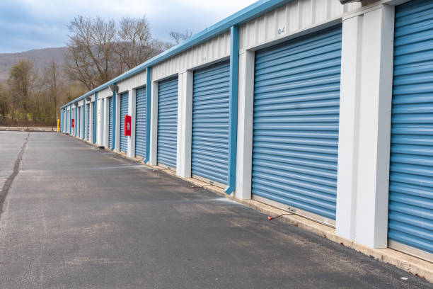 istock Rental storage units and climate controlled self storage facility with fire extinguishers mounted between the roller doors. Beautiful exterior view with a mountain background located near Huntsville Alabama. 1475254021