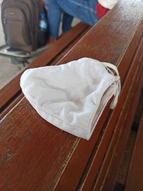 istock white Cloth mask on wood seat 1475256146