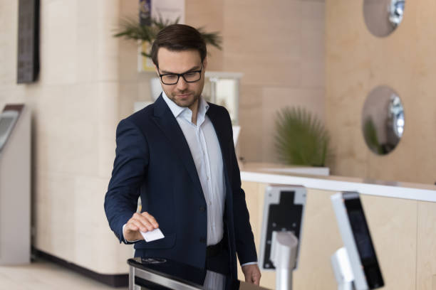 Businessman using pass card open automatic gates in modern office stock photo