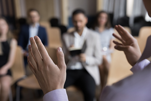 Close up unrecognizable business trainer coach provide information to participants, group of people gathered in seminar, writing new received knowledge. Counselling meeting, lecture for students event