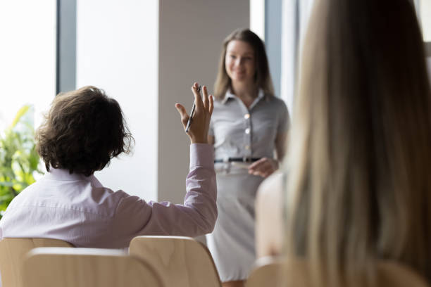 istock Rear view of educational seminar participant raises arm having question 1475257953