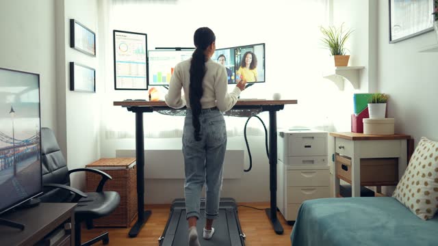Woman at standing desk home office talking on business video call