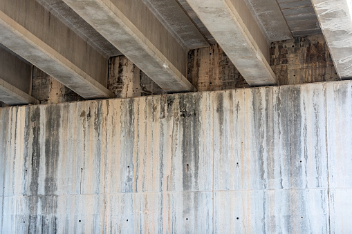 Urban Infrastructure: Underpass Beneath Busy Highway, Concrete Columns and Shadows, Symmetry and Architecture