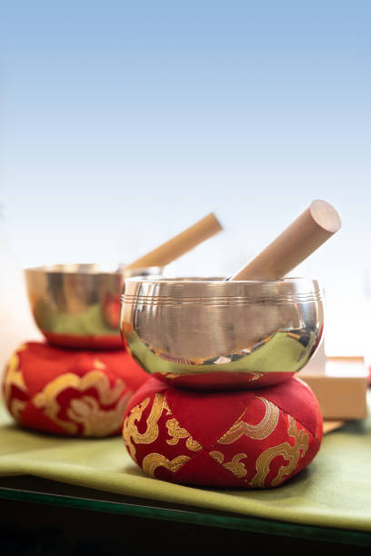 Two singing bowls or standing bells on red cushions with golden embroidery, used for music, meditation and relaxation or for personal spirituality, copy space, selected focus