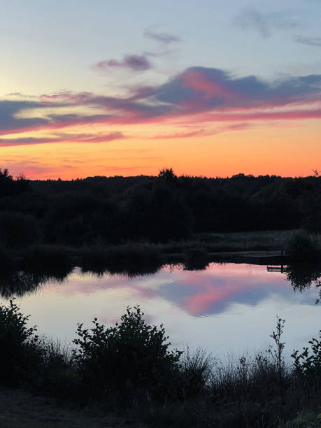 colorido reflejo del atardecer sobre un pequeño lago con silueta natural. - eleanor fotografías e imágenes de stock