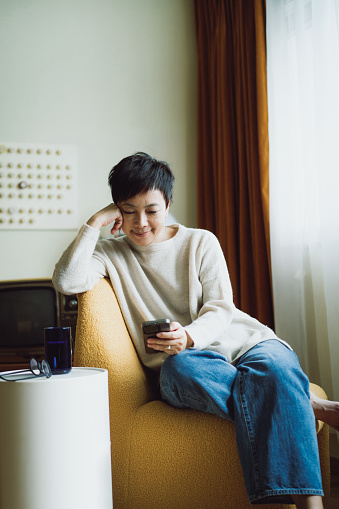 Senior Asian woman using smartphone at home