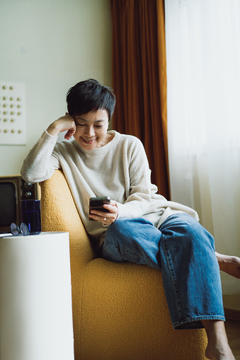 Senior Asian woman using smartphone at home