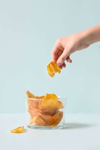 istock Child hand take organic jackfruit chips from glass jar. 1475266796