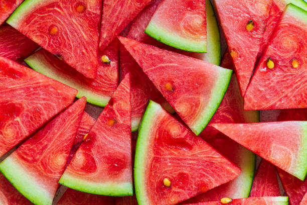 macro sandía en rodajas, pieza triangular de sandía roja sobre fondo negro blanco - watermelon fotografías e imágenes de stock