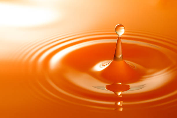 istock Macro orange drop,Macro orange water drop texture,Falling drop in orange water with splash,The waves after a few drops of orange juice. 1475267253