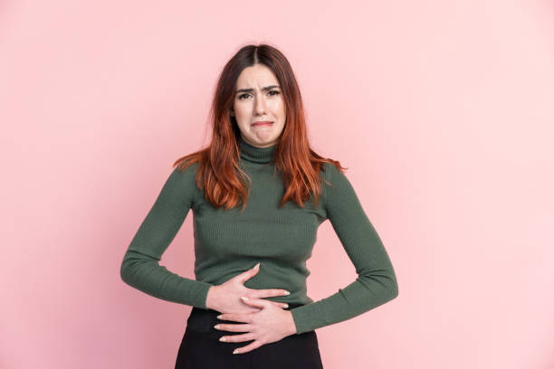 istock Smiling woman with hands in stomach in studio 1475267254