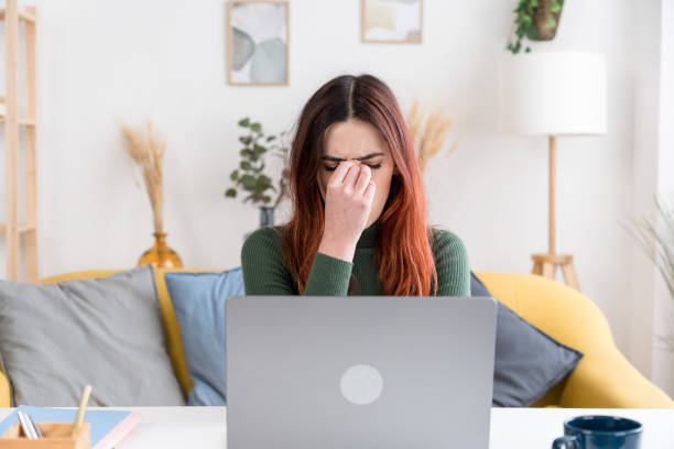 istock tired woman working on laptop at home 1475268194