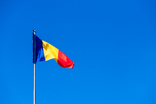 Romanian flag against a blue sky
