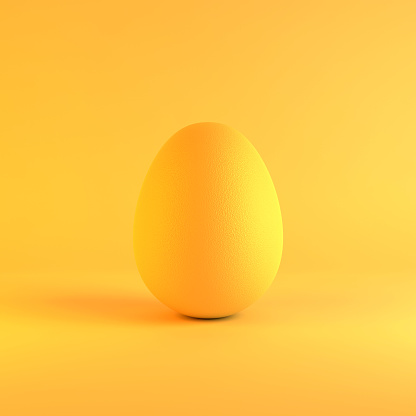 Modern yellow colored Easter egg on yellow background. Easter, standing out from the crowd and individuality concept. Easy to crop for all social media and print design sizes.