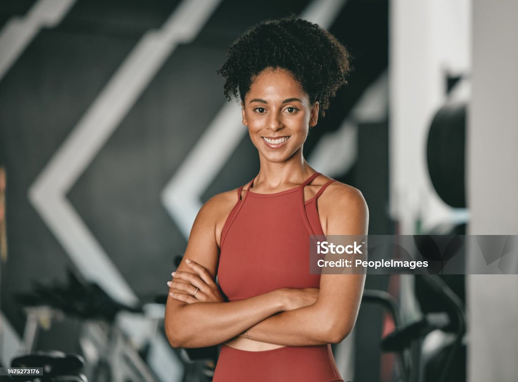 Black woman, fitness and coach with arms crossed and smile for training, exercise or workout at the gym. Portrait of a confident African American female sports instructor with vision for healthy body Health Club Stock Photo