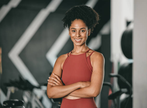 black woman, fitness and coach with arms crossed and smile for training, exercise or workout at the gym. portrait of a confident african american female sports instructor with vision for healthy body - instructor exercising gym women imagens e fotografias de stock