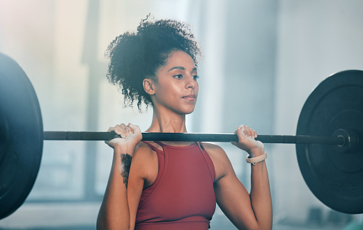 Gym, barbell workout and black woman doing muscle fitness performance, strength training or bodybuilding. Strong exercise girl, body health or bodybuilder weightlifting for athlete wellness lifestyle
