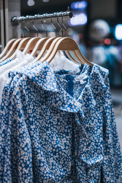 istock Blue women's dresses with floral pattern hanging on a hanger in a row. 1475273380